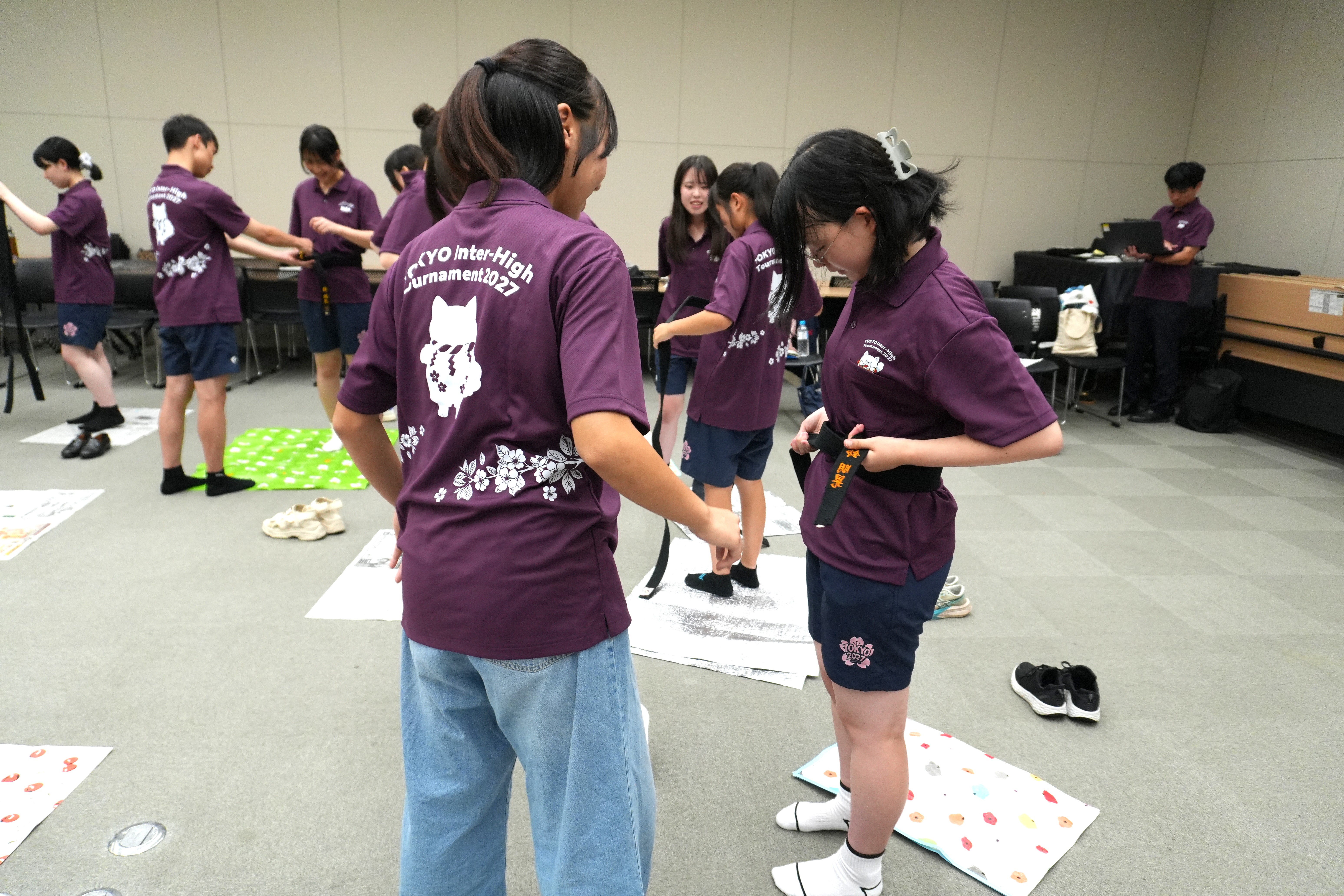 本物の帯を使って帯締めを体験する推進委員