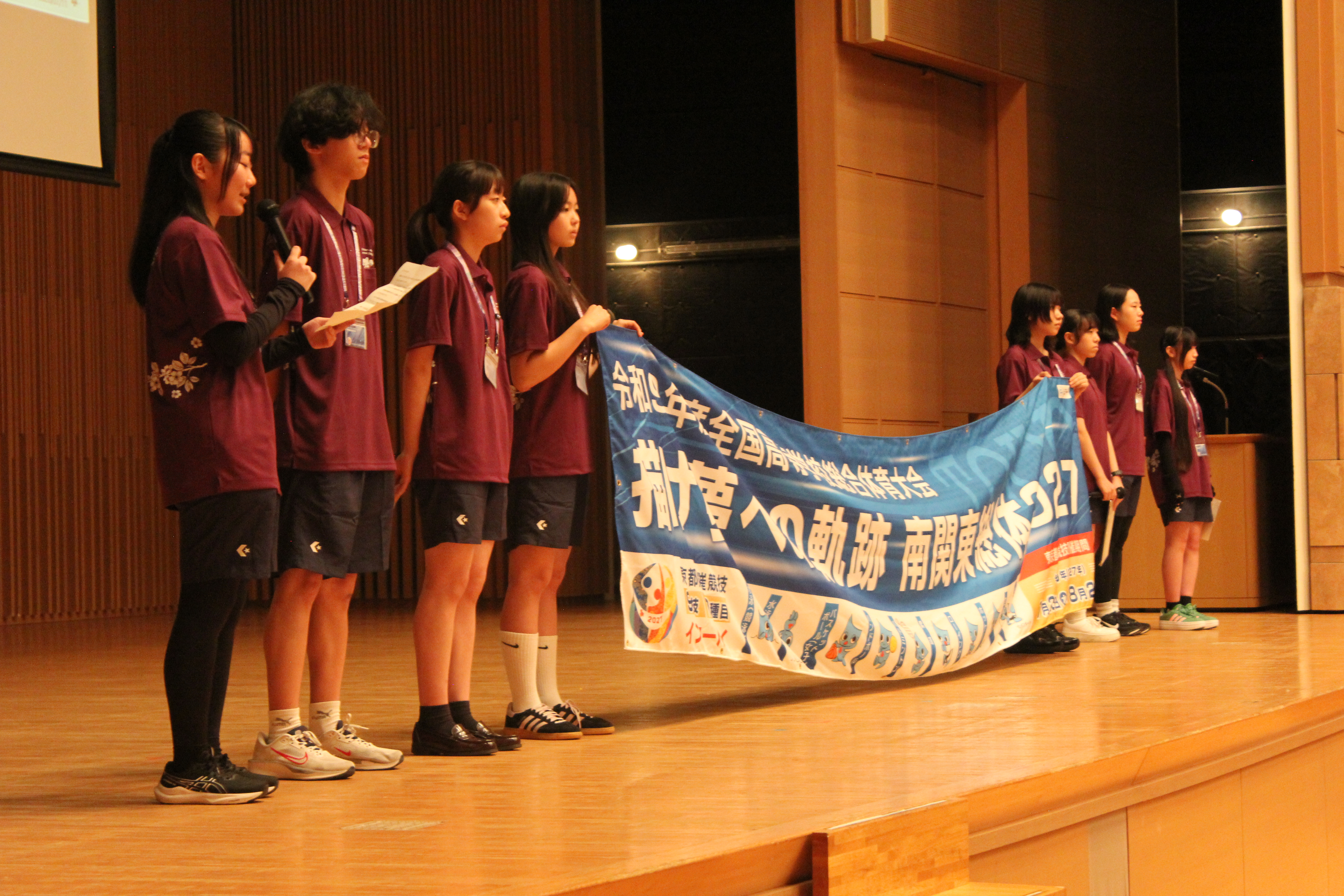 国立オリンピック記念青少年総合センター大ホール舞台上にて東京都選手団にエールを送る推進委員の写真