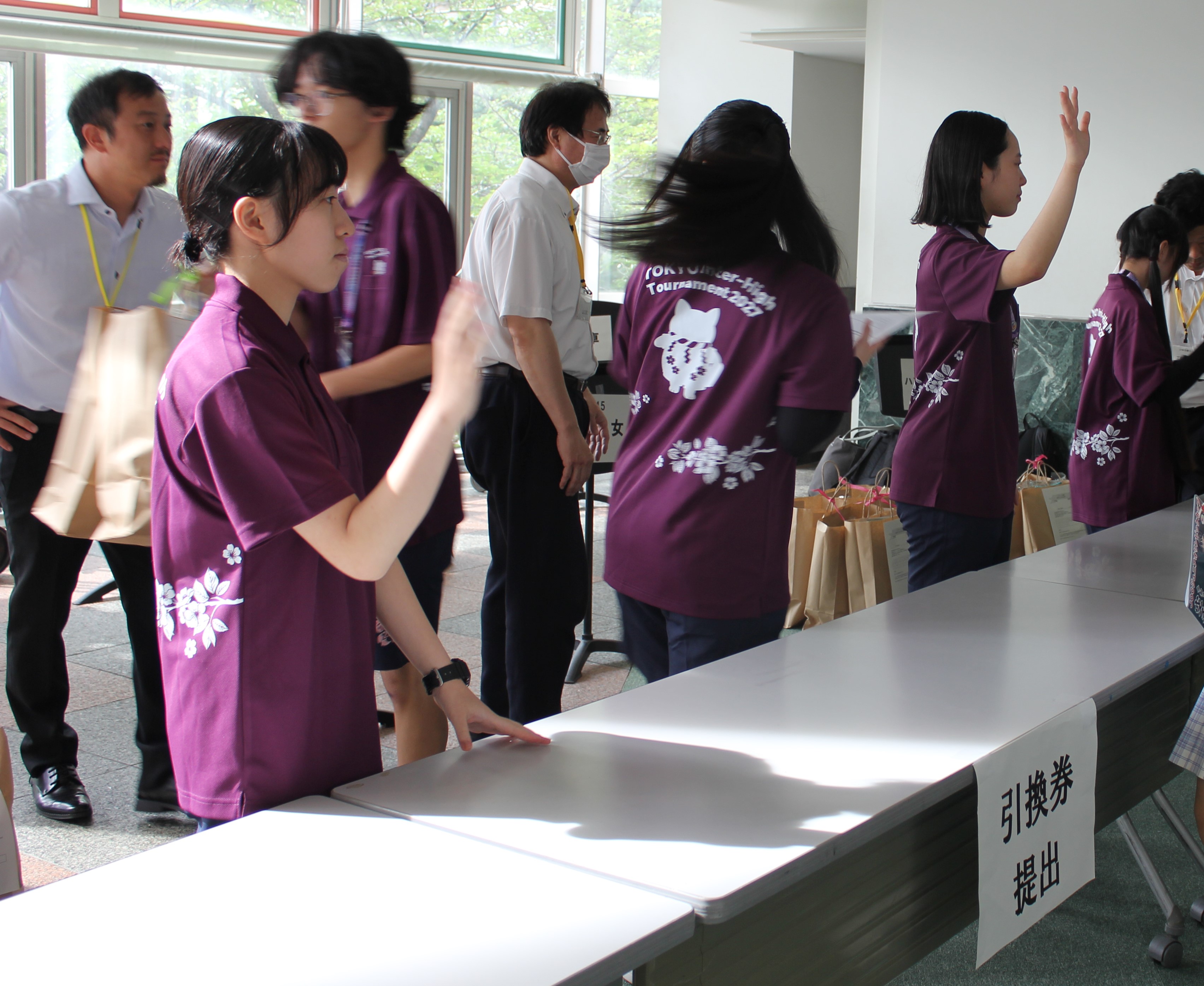 東京都代表選手団にユニフォームを配布する推進委員の写真