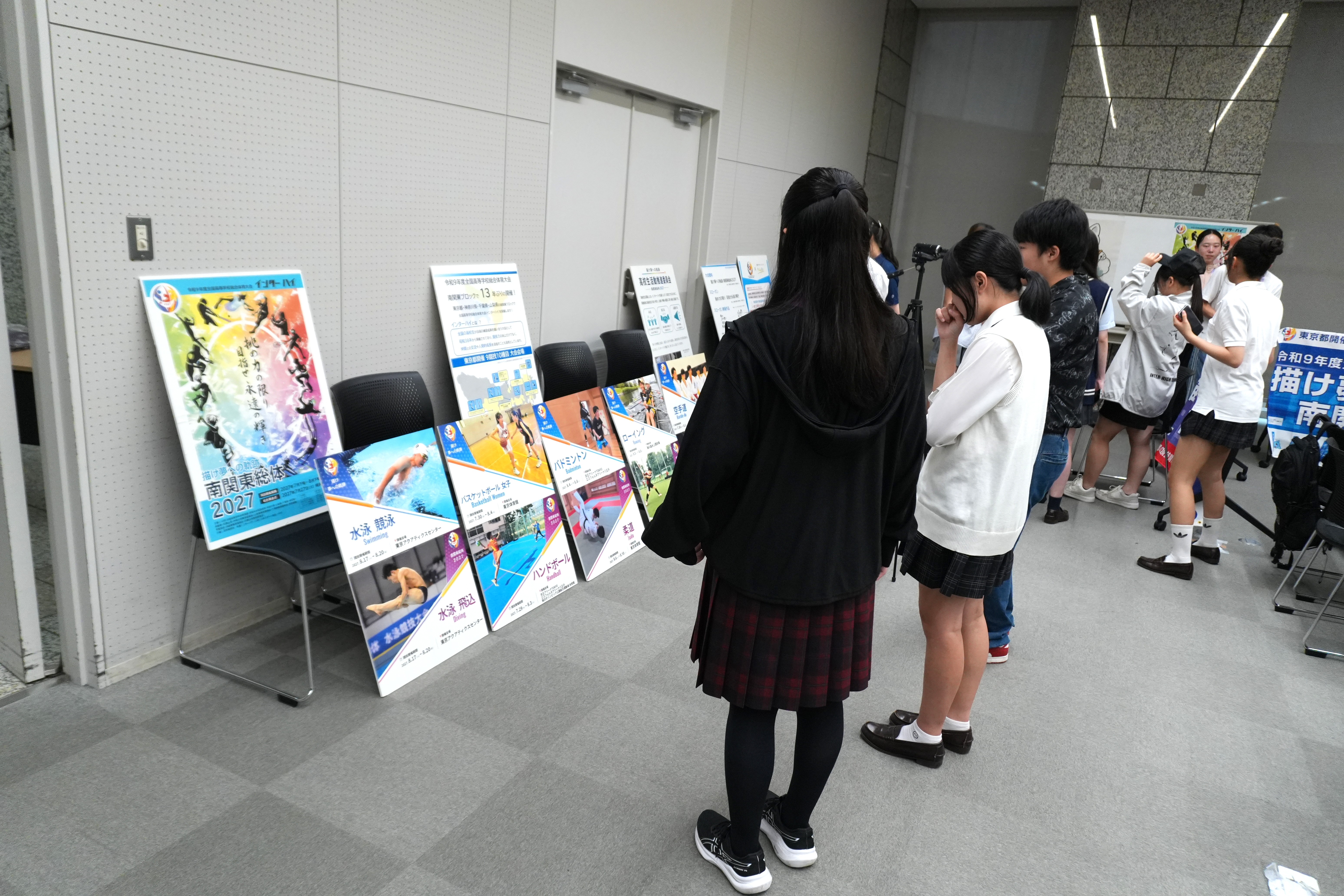 インターハイPR展示で用いたパネルを見る推進委員の写真