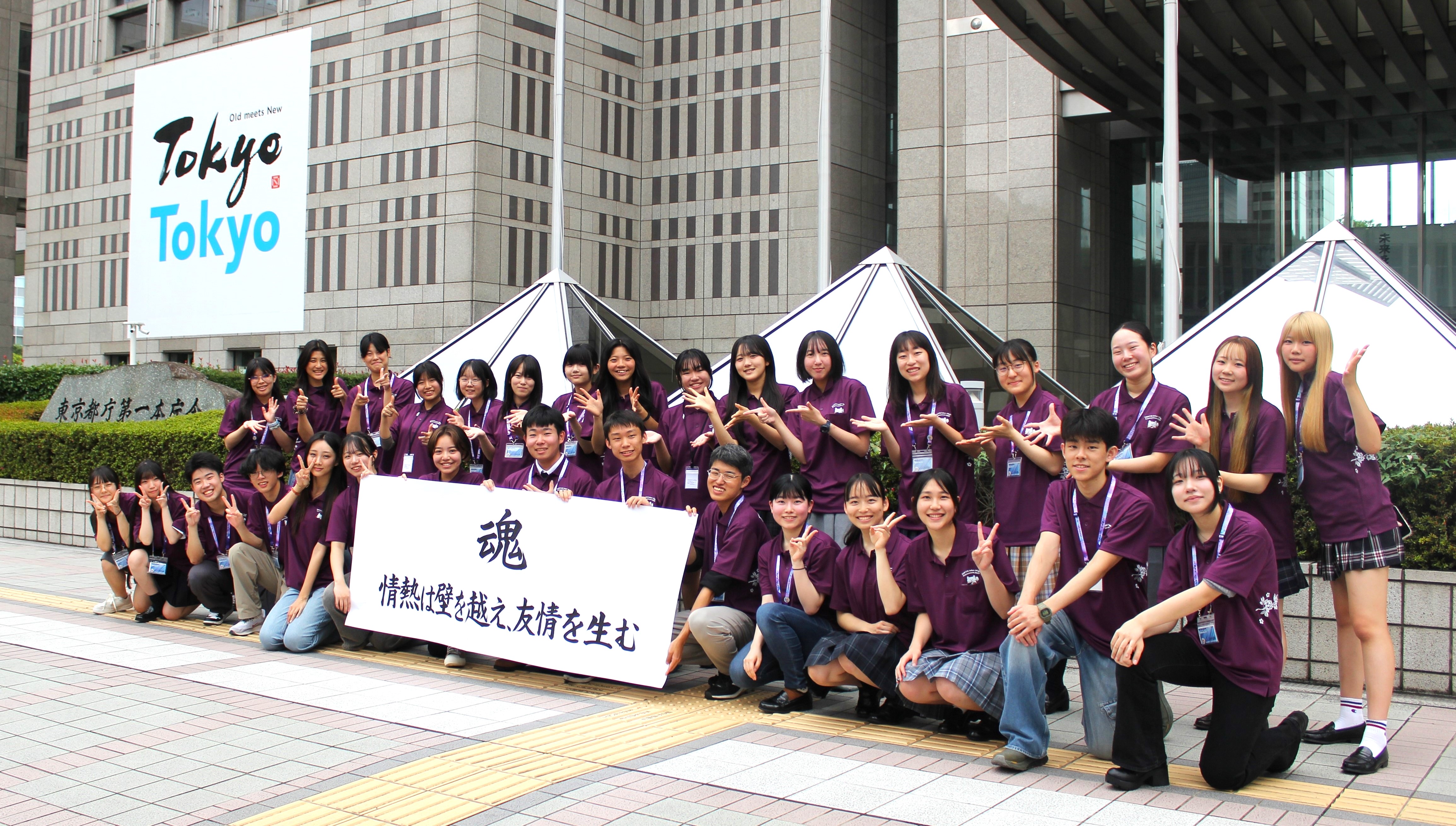 推進委員が東京都第一本庁舎前で集合し、スローガンを持って記念撮影を行う様子