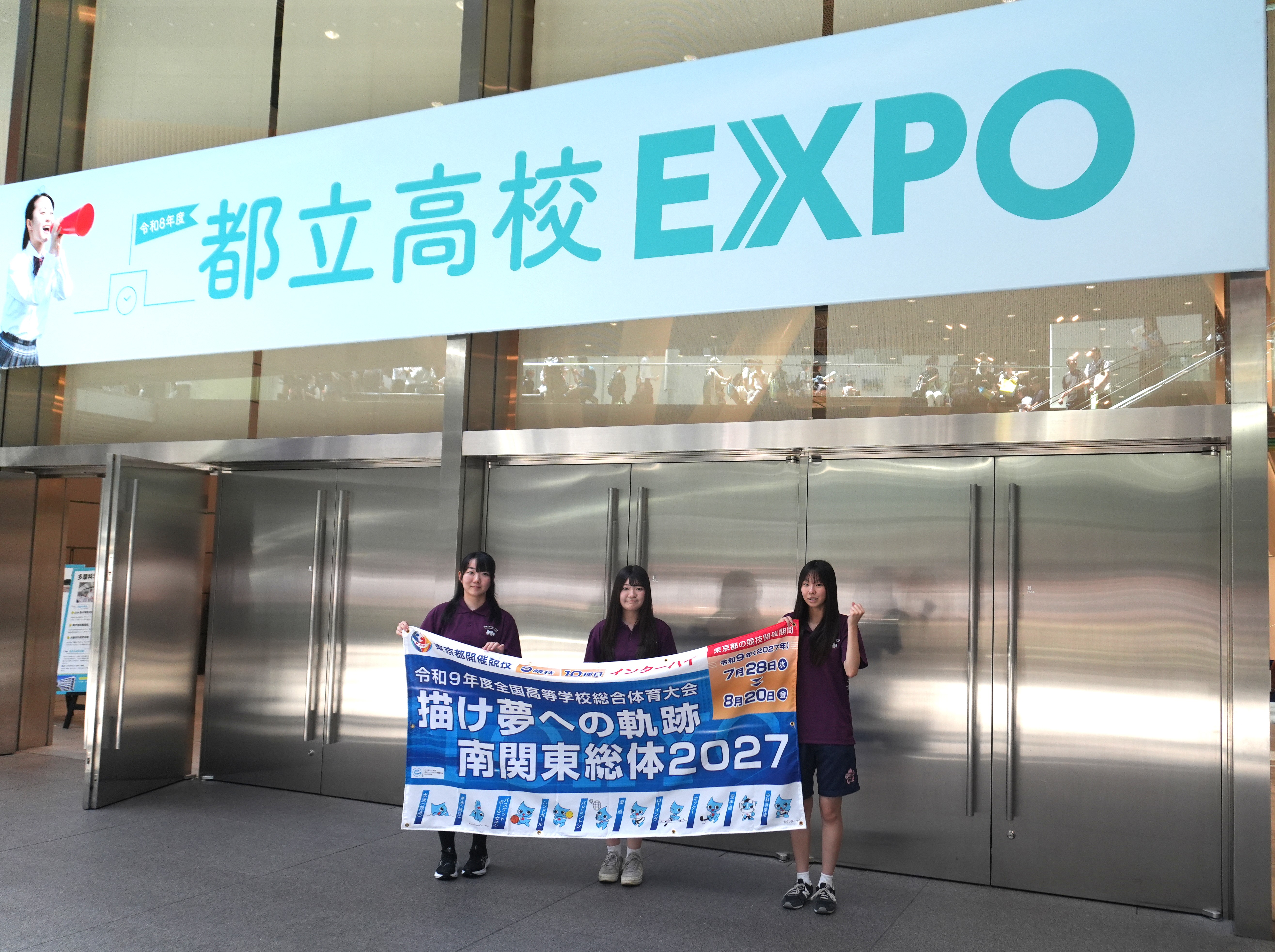 都立高校EXPO会場入口で横断幕を持って記念撮影をする推進委員