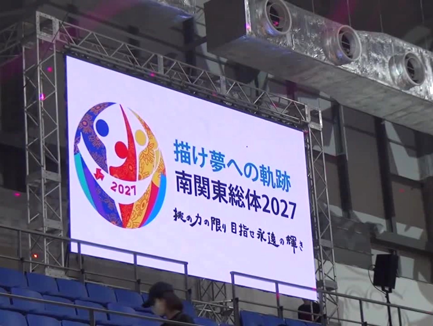 会場内の大型ビジョンに表示された大会広告